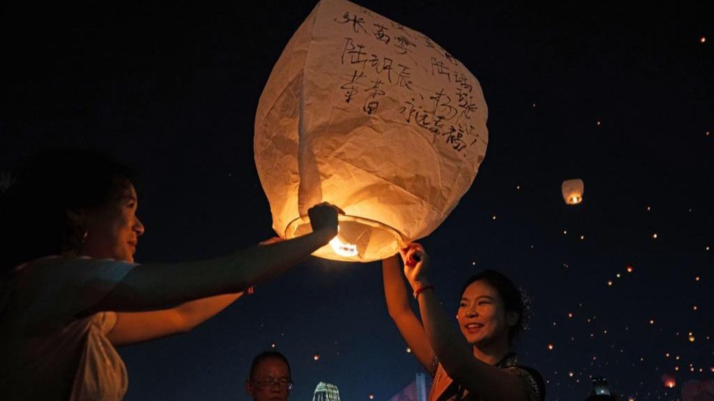 People fly Kongming lanterns in Jinghong, China's Yunnan