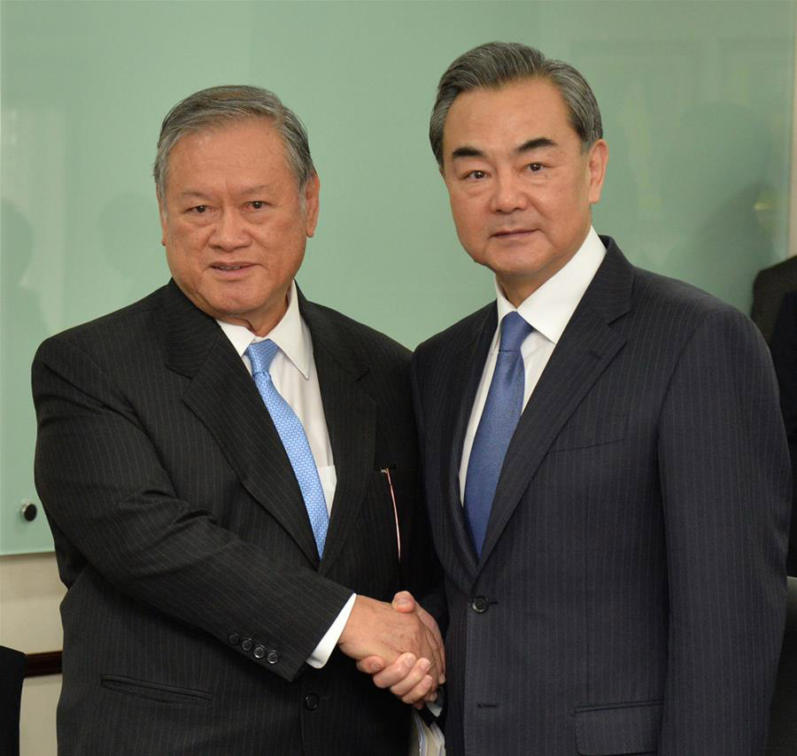 Visiting Chinese Foreign Minister Wang Yi (R) shakes hands with Brunei