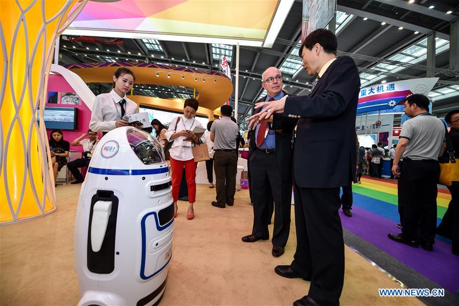 An exhibitor introduces a life-serve robot to visitors.
