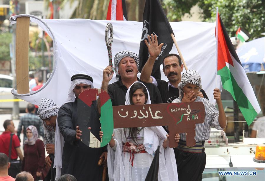 Palestinians hold a large key, symbolising the homes left by Palestinians in 1948, during a rally to commemorate the 68th anniversary of Nakba, meaning catastrophe, the day when the state of Israel was created, in the West Bank city of Nablus, on May 15, 2016. Since 1948, the Palestinians all over the world mark Nakba on May 15. According to the Palestinian Statistics Bureau Center, 957,000 Palestinians left their homes in towns, cities and villages in 1948, which represents 66 percent of the total number of Palestinians who lived in historic Palestine at that time. (Xinhua/Nidal Eshtayeh)