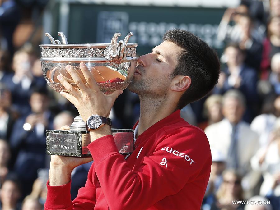 Novak Djokovic of Serbia kisses the champion trophy during the awarding ceremony for the men