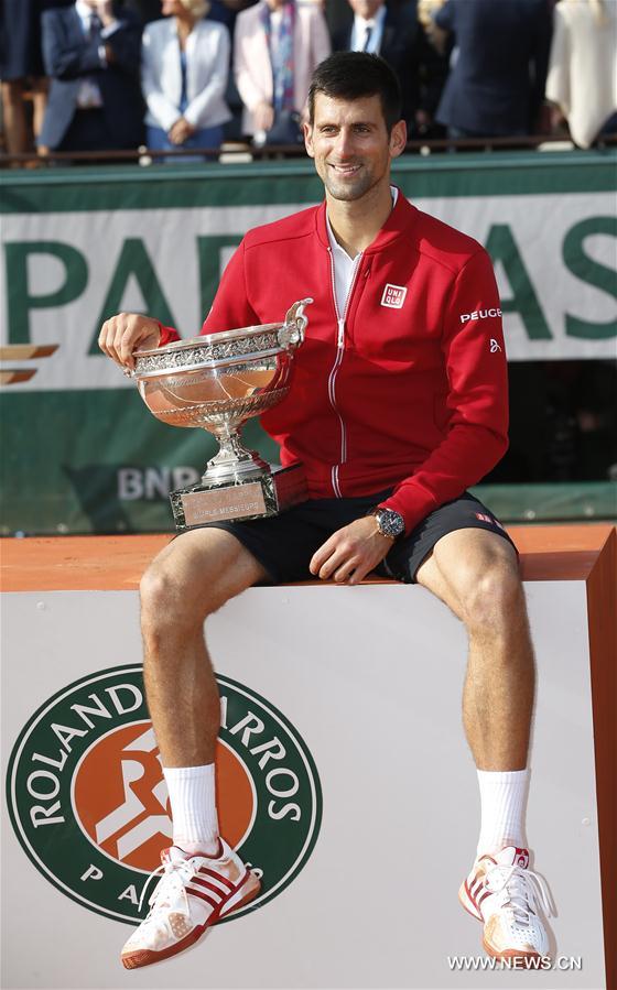 Novak Djokovic of Serbia poses for photos with the champion trophy during the awarding ceremony for the men