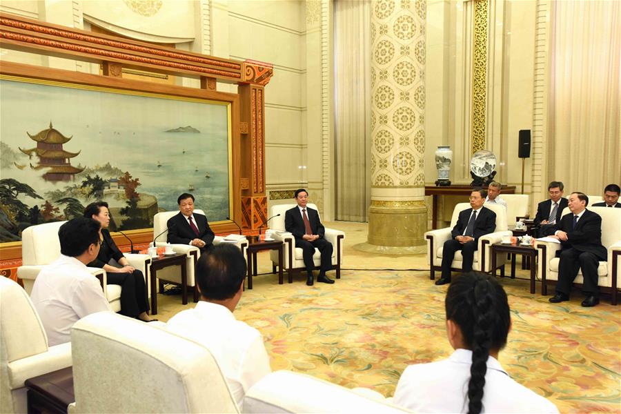  Liu Yunshan (2nd L), a member of the Standing Committee of the Political Bureau of the Communist Party of China (CPC) Central Committee and secretary of the Secretariat of the CPC Central Committee, meets with group members publicizing the deeds of Li Baoguo, a late forestry professor who championed poverty alleviation through afforestation, before a seminar on Li