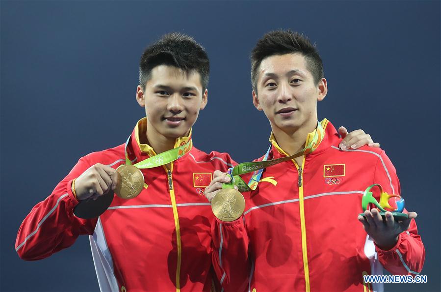 Lin Yue (R) and Chen Aisen of China show gold medals at the awarding ceremony of the men