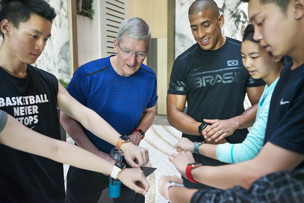 Apple CEO Tim Cook looks at Apple watches being worn by Chinese fitness students in Beijing, on August 16, 2016. [Photo provided to chinadaily.com.cn]