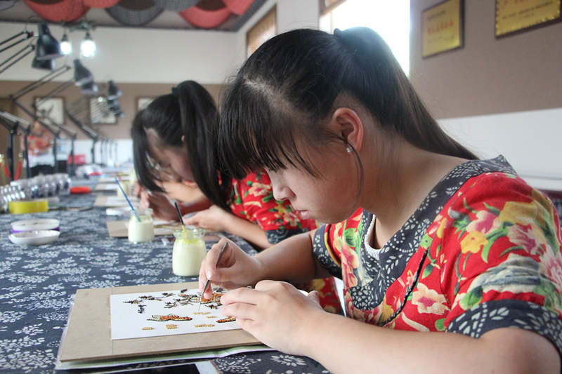 村民正在粮画制作间进行粮画创作