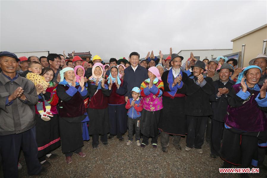 Chinese President Xi Jinping poses for a group photo with villagers in a village of Wushi Township of Huzhu Tu Autonomous County in Haidong, northwest China