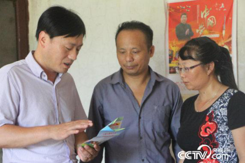 于都县卫计委爱卫会副主任蓝剑锋正在耐心的跟村民段绍平讲解&ldquo;五道保障线&rdquo;政策。