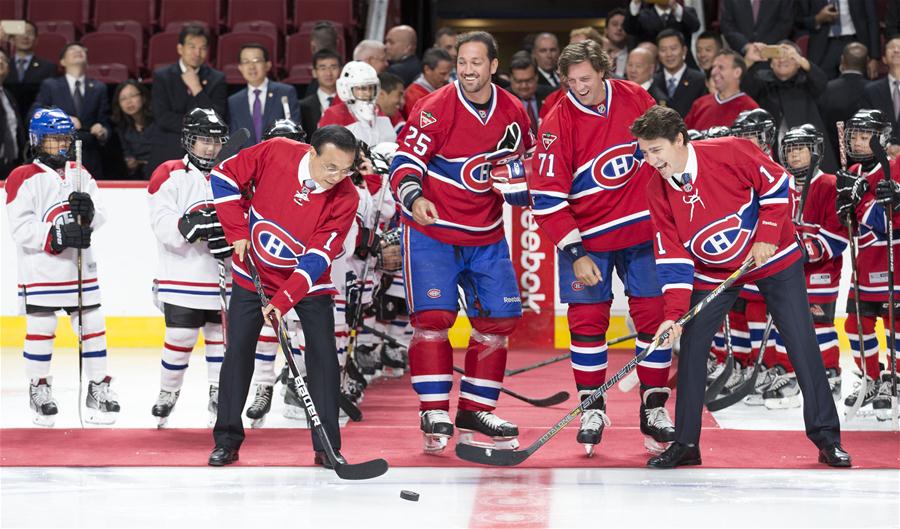 Chinese Premier Li Keqiang and his Canadian counterpart, Justin Trudeau, drop the ceremonial first puck for a training game of young players of Chinese origin as they visit Bell Center of renowned Canadian ice hockey team Montreal Canadiens in Montreal, Canada, Sept. 23, 2016. (Xinhua/Huang Jingwen)