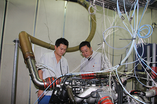 鹿新弟正在和工友解决研发中的问题