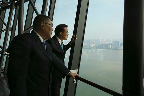Premier Li Keqiang, right, climbs to the top of Macao Tower on Oct 10 accompanied by Macao&rsquo;s Chief Executive Chui Sai On, left. [Photo/provided to chinadaily.com.cn]