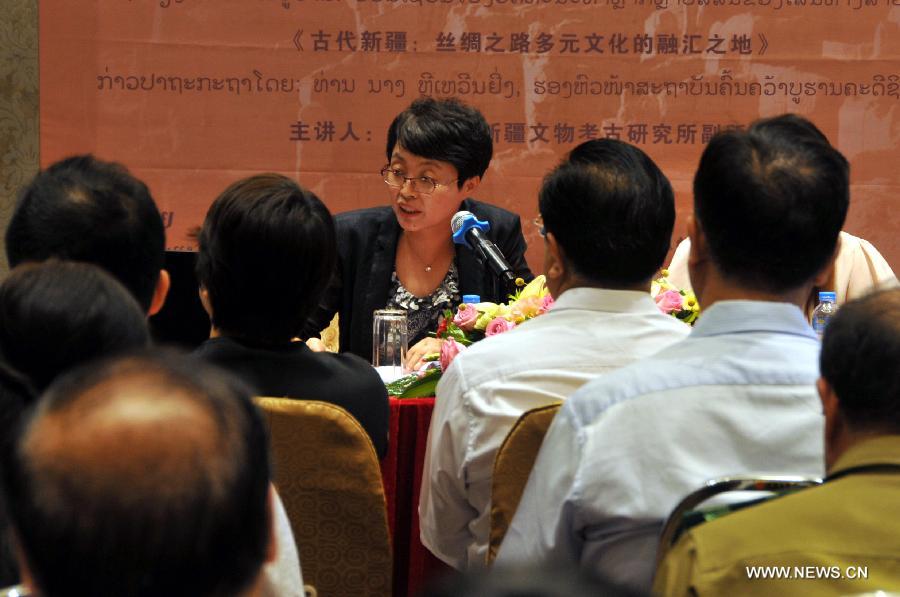 Li Wenying (back), deputy director of Xinjiang Institute of Cultural Relics and Archaeology, speaks during a lecture "Discovering the mystery of Xinjiang" in Vientiane, Laos, Oct. 10, 2016. A lecture to introduce the cultural features of China
