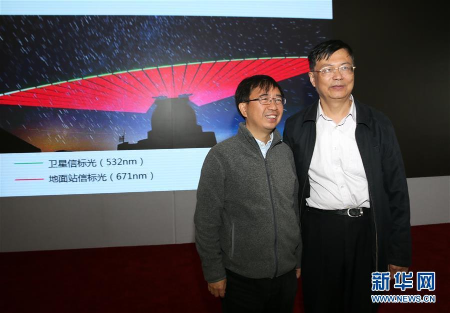 Pan Jianwei (L), the leading scientist in China&rsquo;s Quantum Science Satellite project, poses with Wang Jianyu, the deputy director of the project, in front of an image showing the transmissions between Quantum Science Satellite Mozi and a ground station during a press conference in Beijing, Oct. 12, 2016. It
