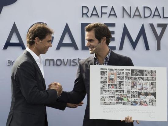 Rafa Nadal presents Roger Federer with a framed picture of their many duels down the years at the opening of his academy on Thursday.