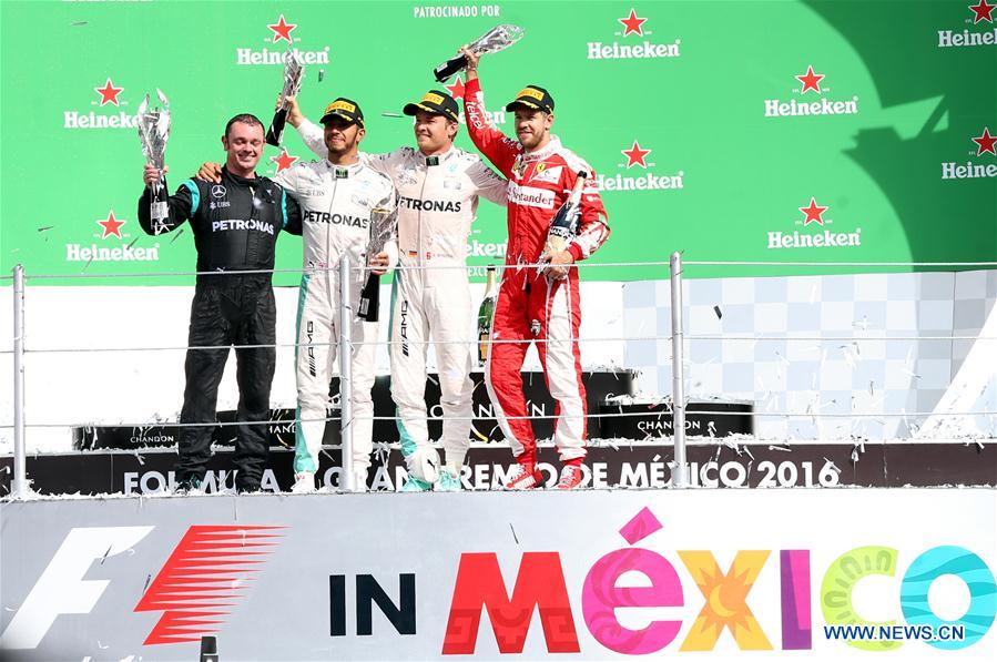 Mercedes team coordinator Tony Walton, Mercedes British driver Lewis Hamilton, Mercedes German driver Nico Rosberg and Ferrari German driver Sebastian Vettel (from L to R) pose on the podium after the Formula One Mexico Grand Prix in Mexico City, capital of Mexico, Oct. 30, 2016. (Xinhua/Str)