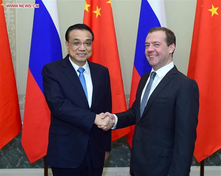 Chinese Premier Li Keqiang (L) shakes hands with his Russian counterpart Dmitry Medvedev at the 21st China-Russia Prime Ministers