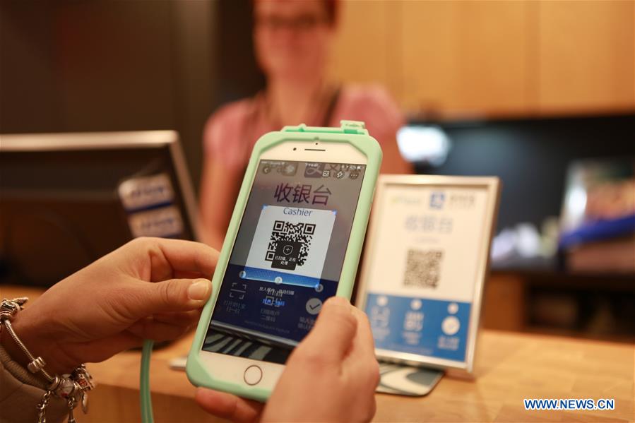 A Chinese tourist pays for souvenirs by scanning Alipay in Rovaniemi, Finland, Dec. 5, 2016. Alipay, the payment service of China