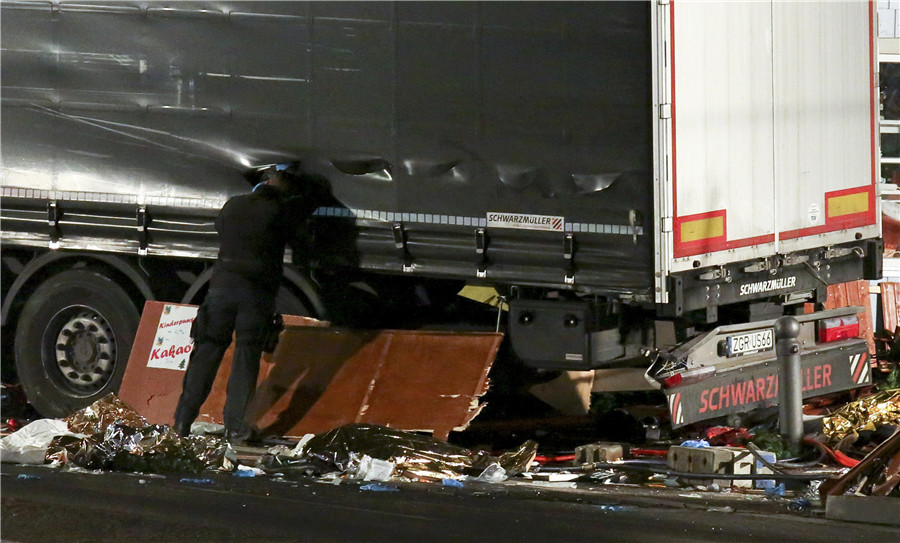 A German police officer looks into a truck at a Berlin Christmas market following an accident with the truck on Breitscheidplatz square near the fashionable Kurfuerstendamm avenue in the west of Berlin, Germany, Dec 19, 2016. 
