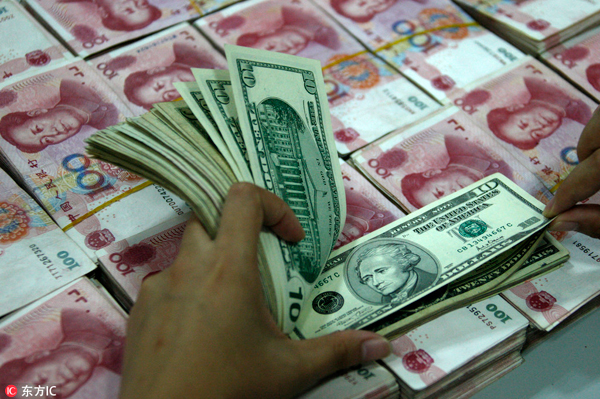 A clerk counts yuan bank notes and US dollar bills at a branch of the Industrial and Commercial Bank of China in Huaibei, East China
