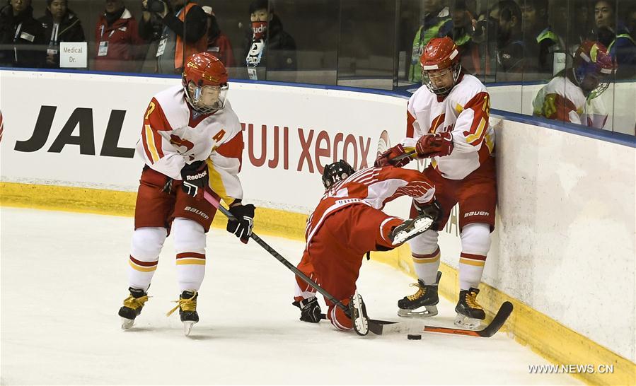 Kong Minghui(R) and Zhang Mengying (L) vie for the puck during the women