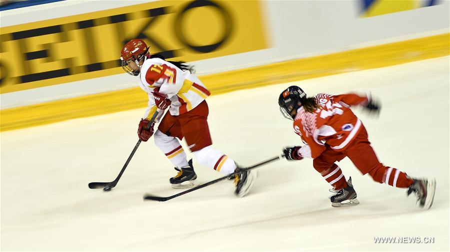 Lyu Yue (L) of China vies for the puck during the women