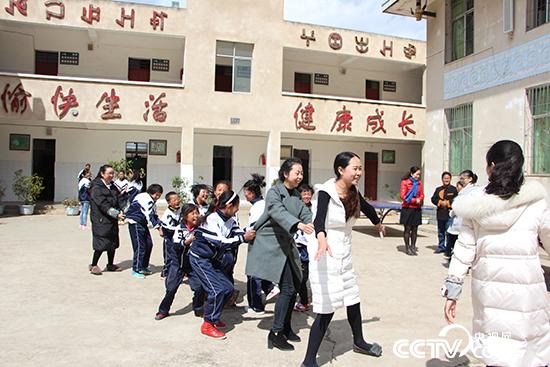 新招来的4名老师，带着小一点的孩子们玩他们最喜欢玩的老鹰抓小鸡。