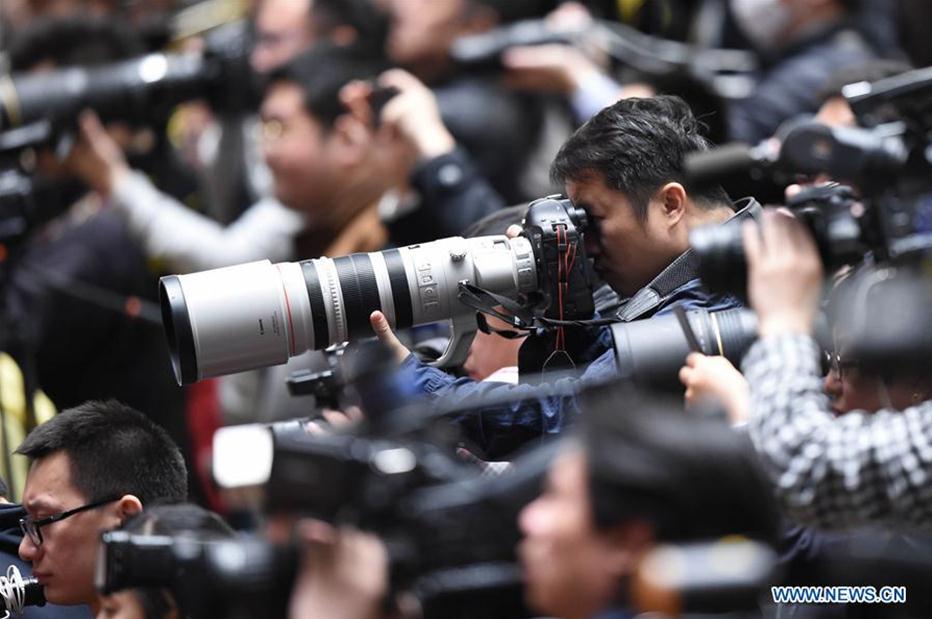 Photographers work at the closing meeting of the fifth session of the 12th National Committee of the Chinese People