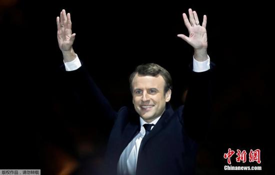 马克龙和妻子布丽吉特在巴黎卢浮宫前举行的庆祝胜选集会上。 <a target='_blank' href='http://www.chinanews.com/' width=