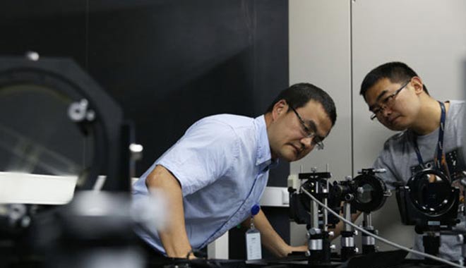 冷用斌（左）和同事在上海光源同步光诊断实验室内做实验（5月27日摄）。新华社记者 裴鑫 摄