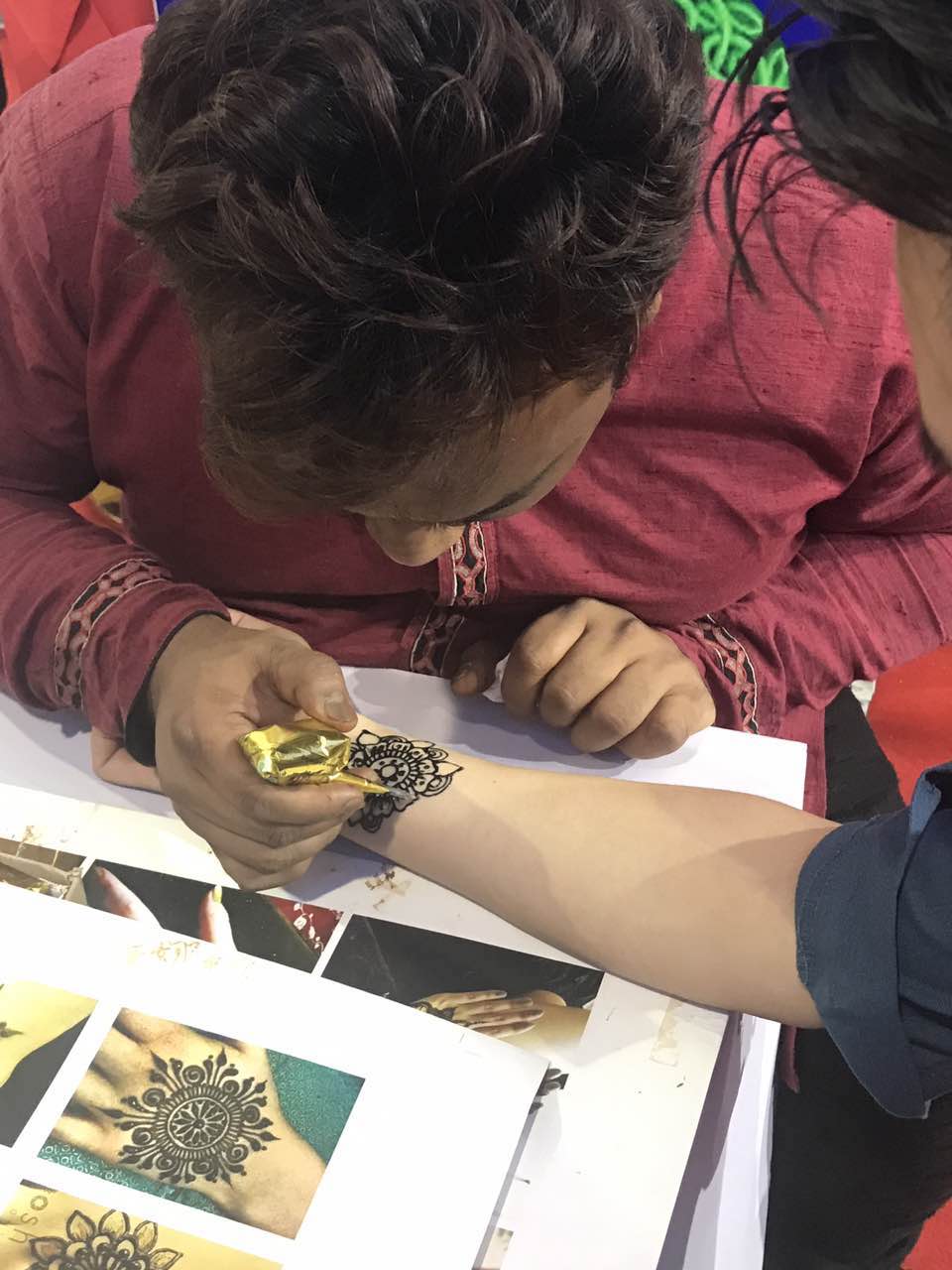 Artist from India painting henna on visitor