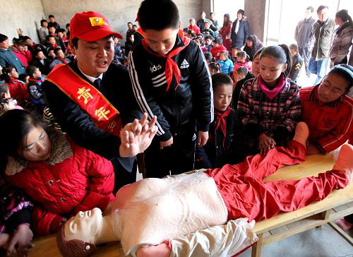 (A volunteer is showing pupils first-aid operations in electricity shocks Photo from Xinhua)