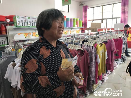 黄兰各拿着爱心卡将在超市兑换大米。（记者 王莉莉 摄）