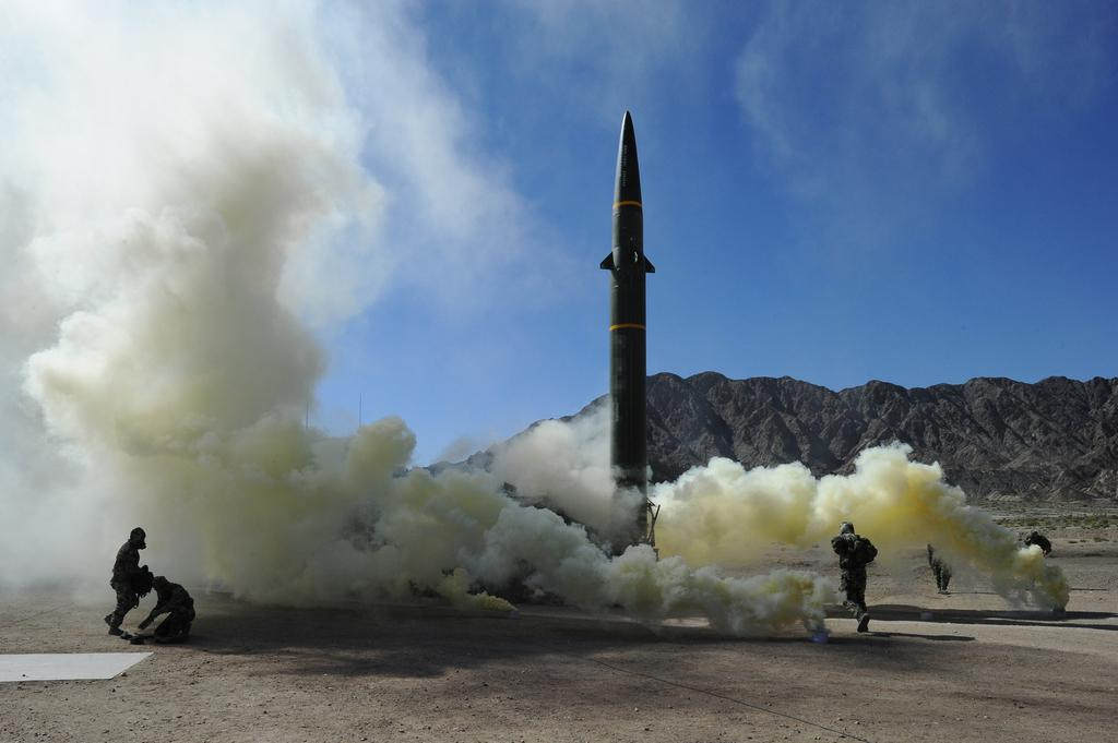 演习中的官兵带上防护面具发射火箭（王杰摄）