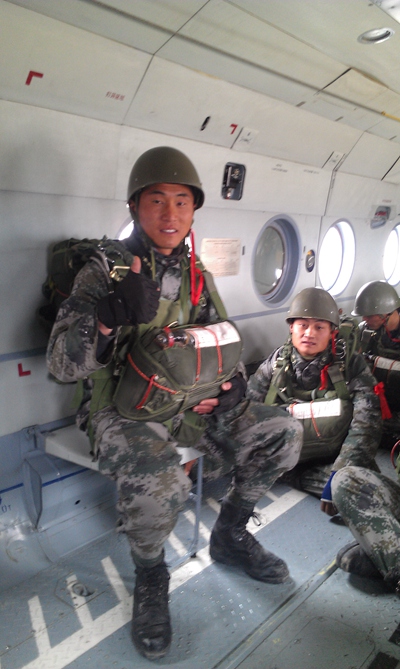 吴建（左一）与战友们在直升机舱内等待跳伞。资料图片