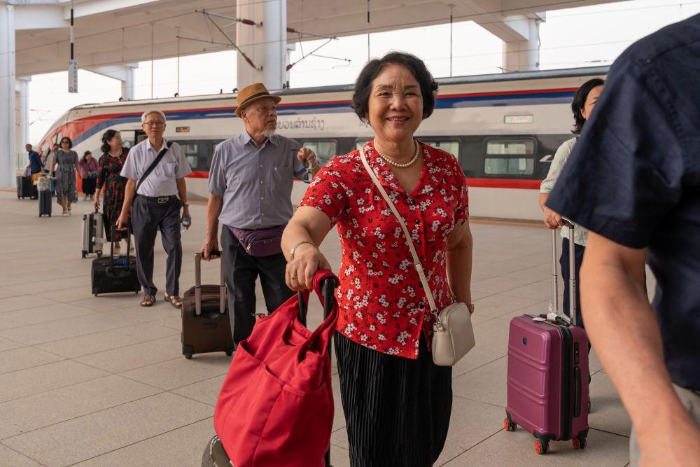 △ 2026年4月13日,乘坐中老铁路国际旅客列车的旅客抵达中老铁路万象站。