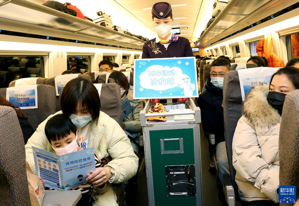1月16日，乘务员在上海虹桥开往汉口的G1724次列车上向旅客分发防疫宣传册。新华社记者 陈飞 摄