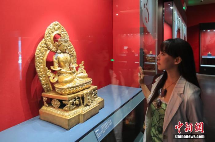 图为观众参观故宫博物院院藏无量寿佛像。 