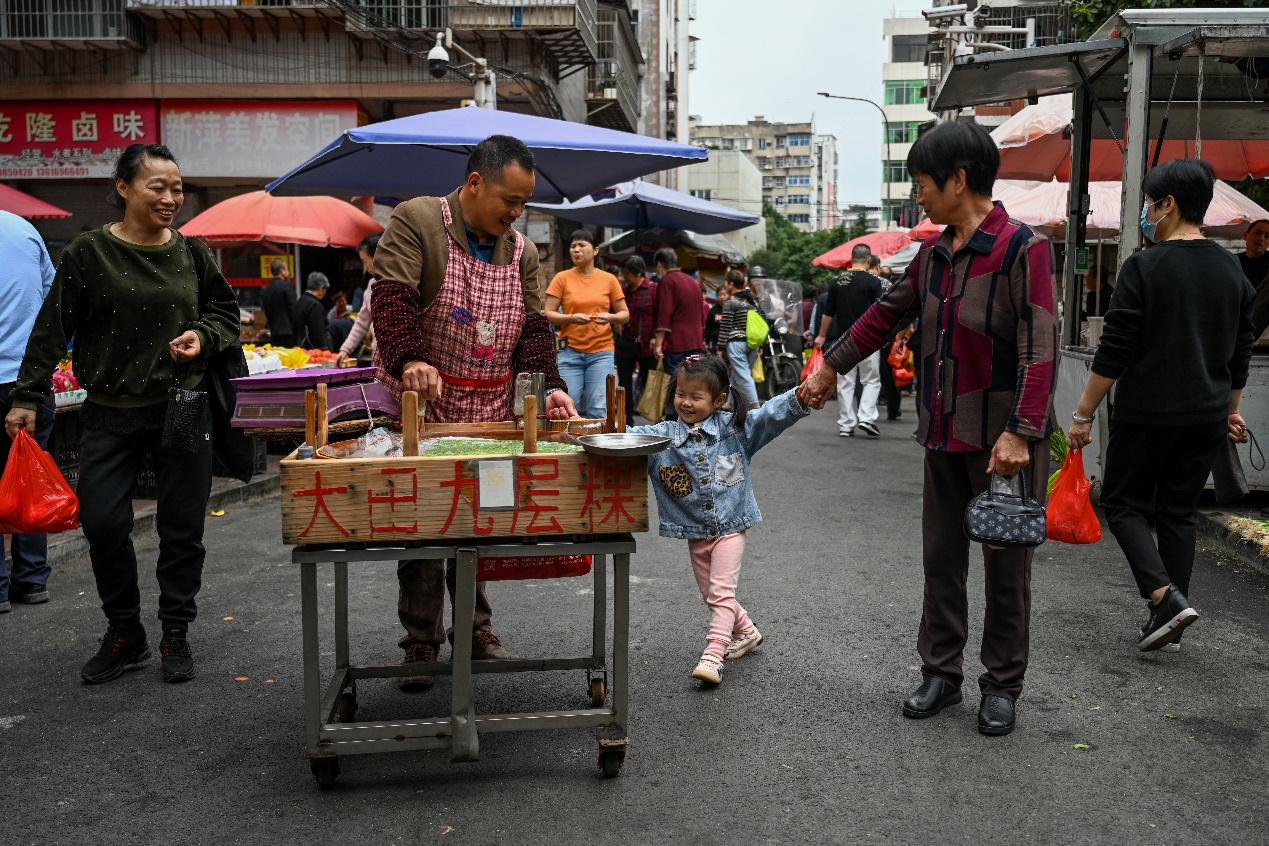 2020年11月23日，三明市广源路菜市场，老人带着孙女在菜市场买菜。