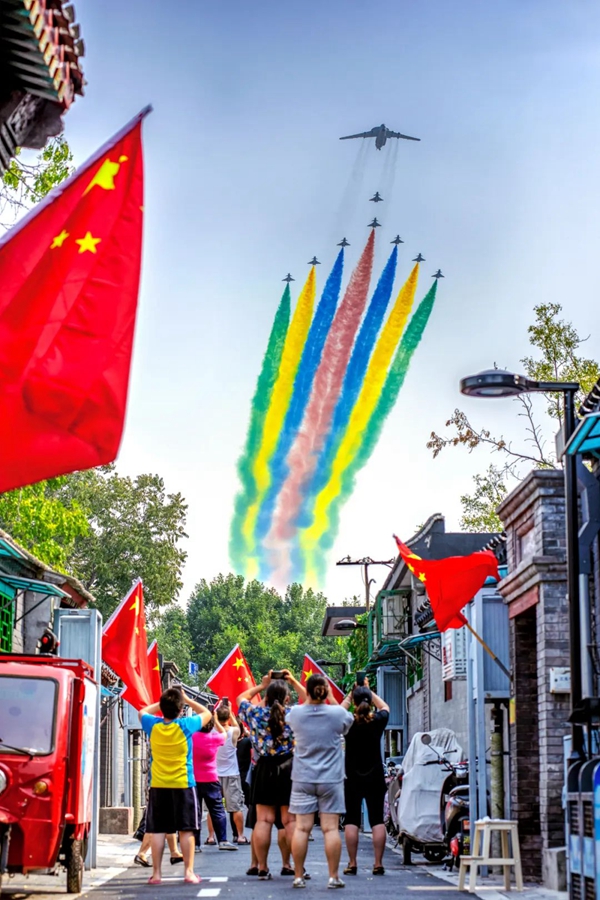 2019年10月1日，庆祝中华人民共和国成立70周年大会上受阅的空中梯队飞过北京宣武门北新华街东侧胡同，市民用手机拍摄下这一时刻。陈玲 摄