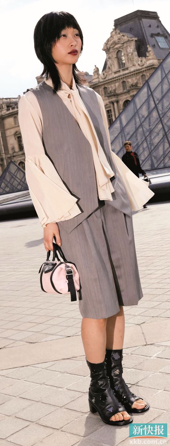 领间垂落的缎带不系紧、不固定，随步伐摇曳，为造型注入柔和气质。